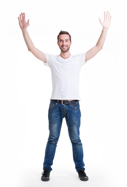 Young happy man in casuals with raised hands up - isolated on white.