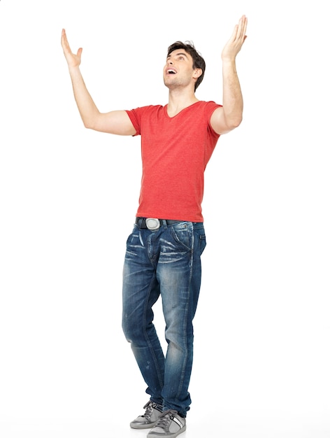 Бесплатное фото Молодой счастливый человек в повседневной одежде с поднятыми руками, изолированные на белом фоне.