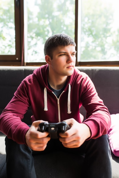 Young happy man laughing and playing video games on weekend