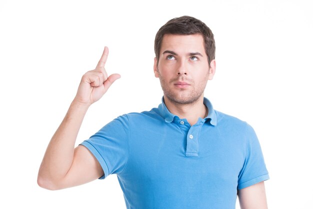 Young happy man with good idea sign  in casuals  looking up isolated on white wall.