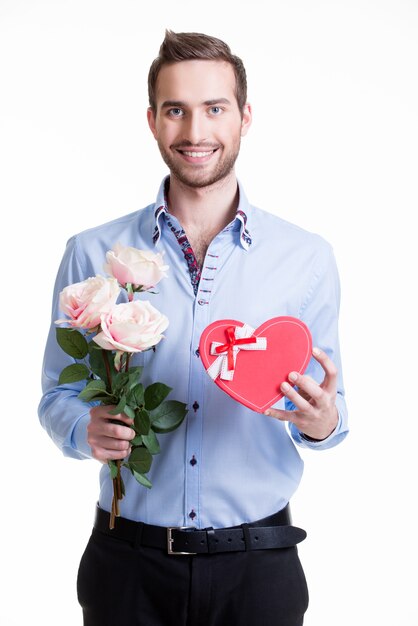 Молодой счастливый человек с розовыми розами и подарком - изолированные на белом