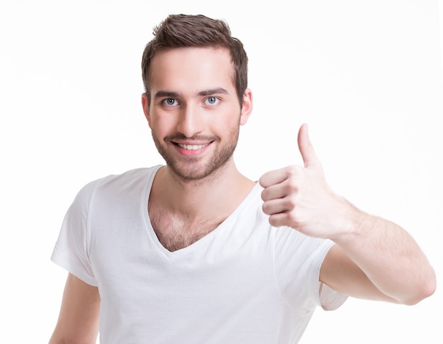 Young happy man with thumbs up sign in casuals isolated on white background.