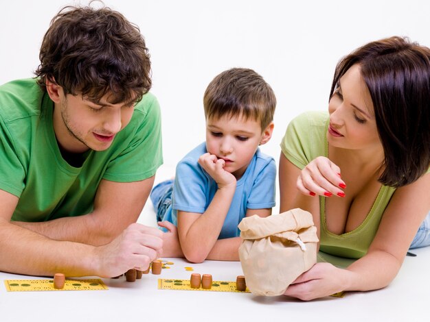 Молодые счастливые родители в помещении, играя с маленьким сыном