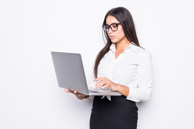 Young happy smiling business woman in casual clothes holding laptop and sending email isolated on white