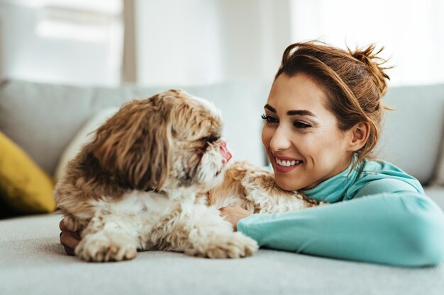 Молодая счастливая женщина наслаждается со своей собакой дома