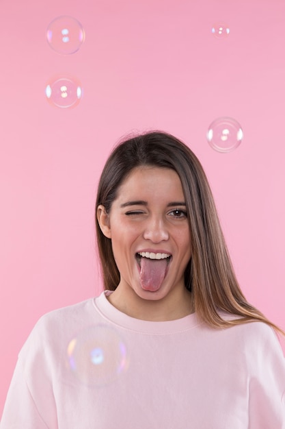 Young happy woman having fun between soap bubbles