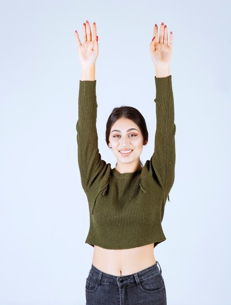 young happy woman model standing and raising her hands.