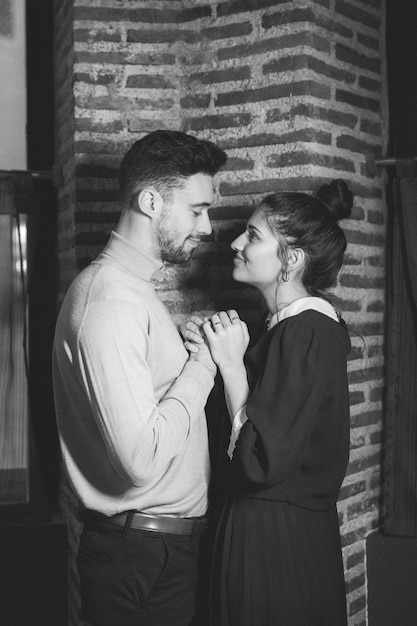 Young happy woman and positive man near brick wall 