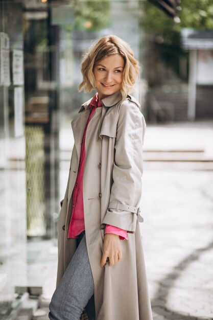 Young happy woman in spring coat out in the city