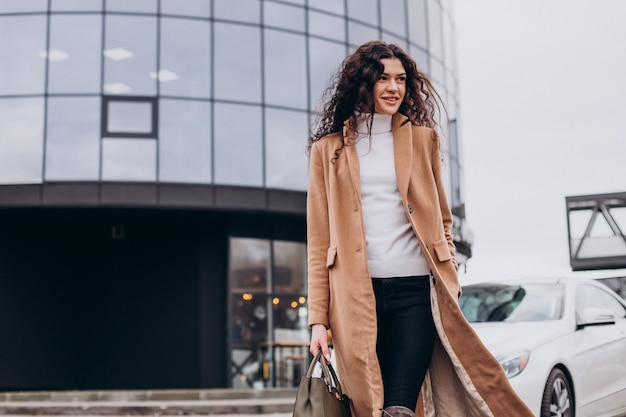 Free photo young happy woman standing by the car