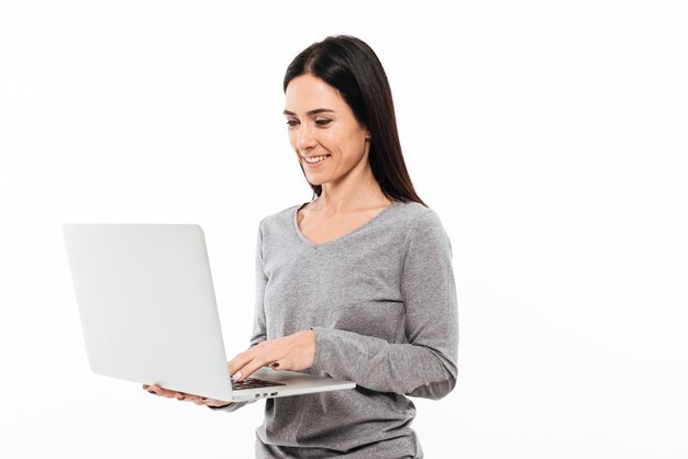 랩톱 컴퓨터를 사용하여 젊은 행복한 여자.