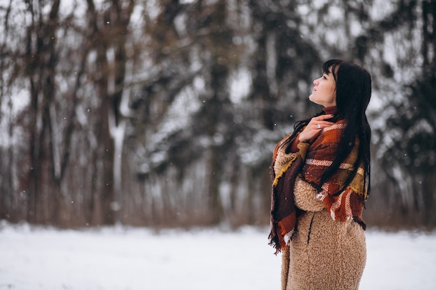 Foto gratuita giovane donna felice in panni caldi in un parco d'inverno