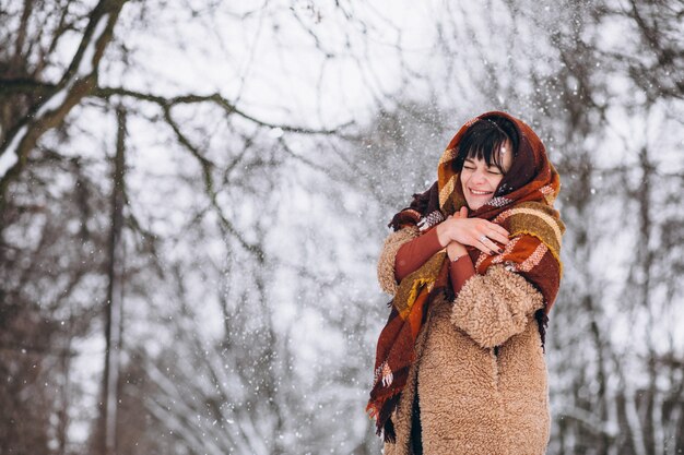 Young happy woman in warm cloths in a winter park