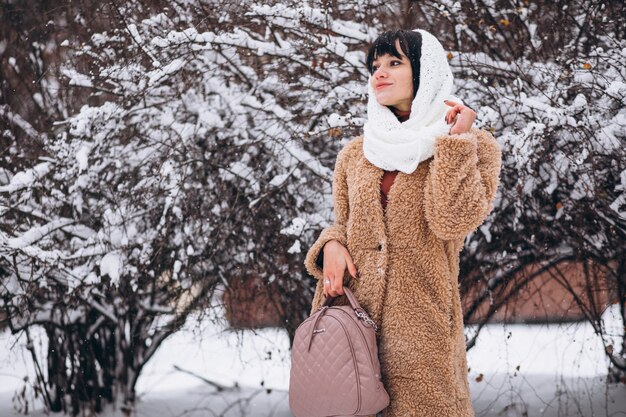 冬の公園で暖かい布で若い幸せな女