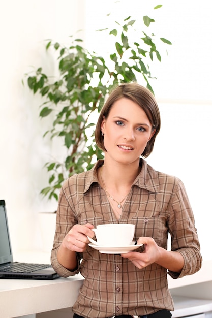 Donna giovane e felice con una tazza di caffè