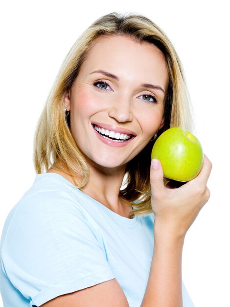 Молодая счастливая женщина с зеленым яблоком - на белом пространстве