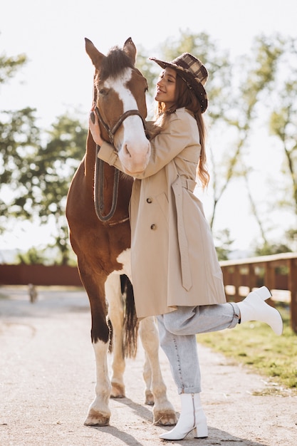 無料写真 牧場で馬を持つ若い幸せな女