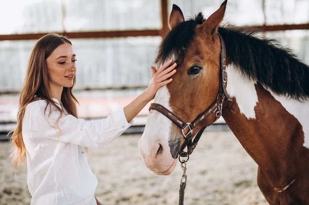 Free photo young happy woman with horse at ranch