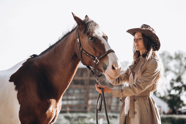 Young happy woman with horse at ranch