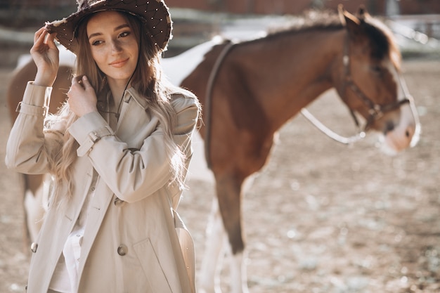 牧場で馬を持つ若い幸せな女