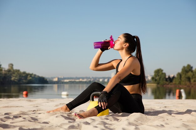 Young healthy woman resting after practicing at the beach