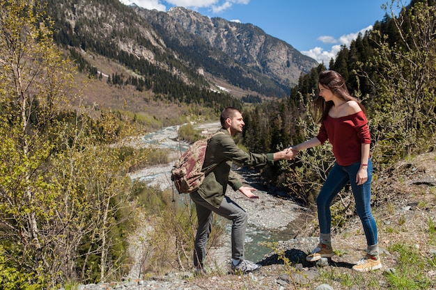 Young hipster beautiful couple hiking at river in forest