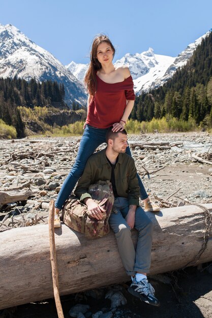 流行に敏感な若い美しいカップルの森の川でハイキング