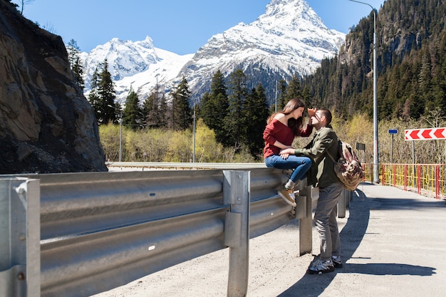 Young hipster beautiful couple in love, sitting at road