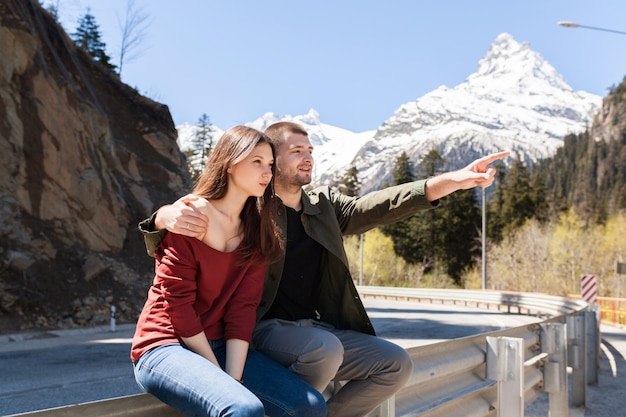 Young hipster beautiful couple in love sitting at road