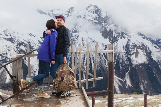 Young hipster beautiful couple in love, walking in mountains