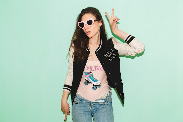 Free Photo young hipster beautiful woman, funny heart sunglasses, against blue wall, cool face expression