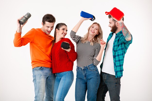 Young hipster company of friends having fun together smiling listening to music on wireless speakers