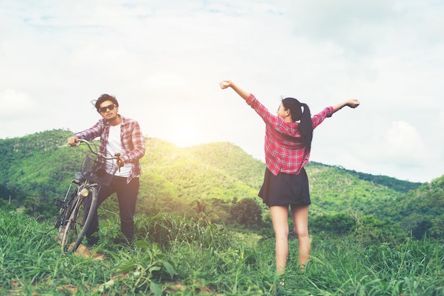 Young hipster couple holding hands walking on the meadow relaxin