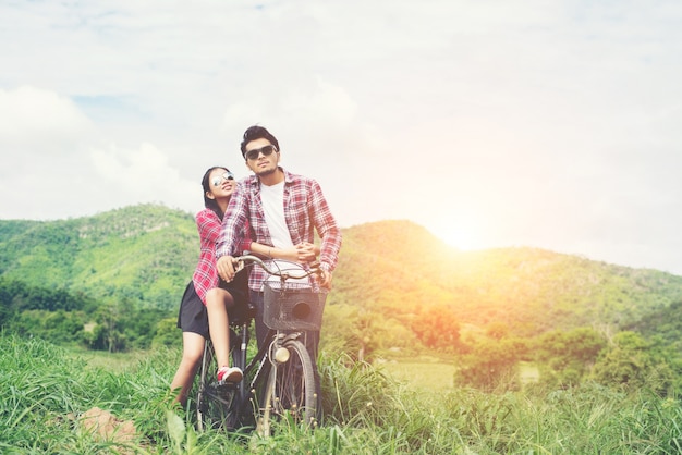 Young hipster couple holding hands walking on the meadow relaxin