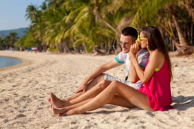 Young hipster couple in love, tropical beach, vacation, summer trendy style, sunglasses, headphones