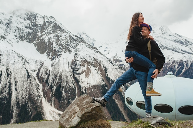 Free photo young hipster couple in love walking in mountains