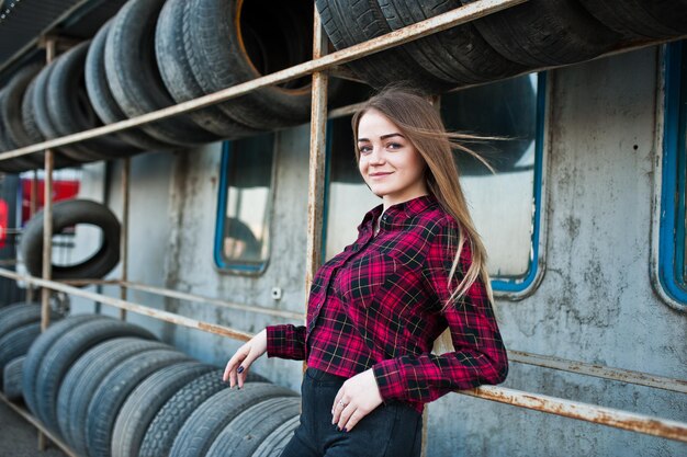 Young hipster girl in checkered shirt at tire fitting zone