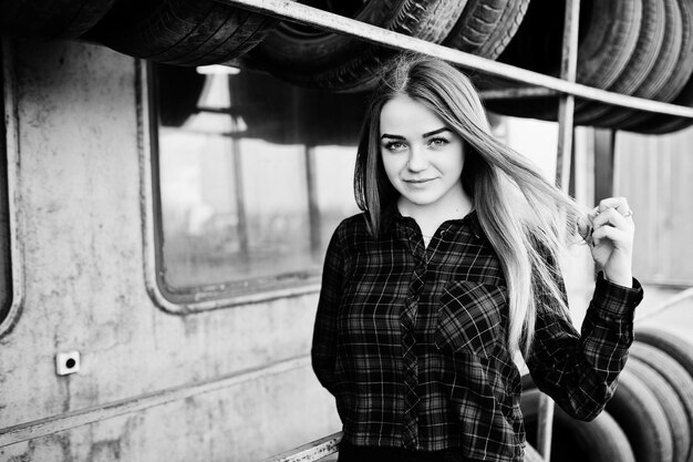 Young hipster girl in checkered shirt at tire fitting zone