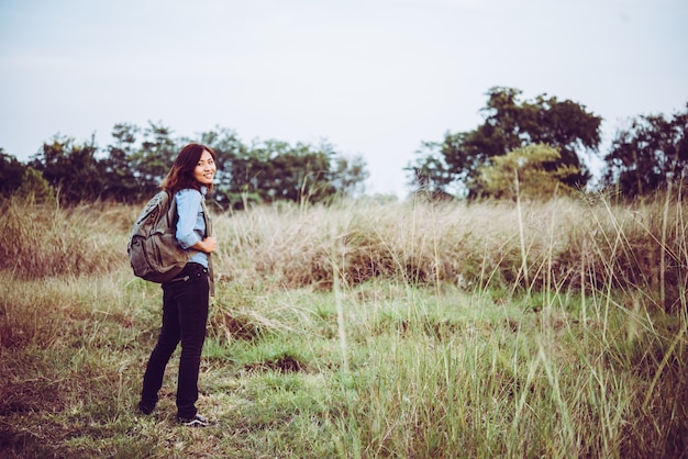 Free photo young hipster girl with backpack walking through in the summer field.