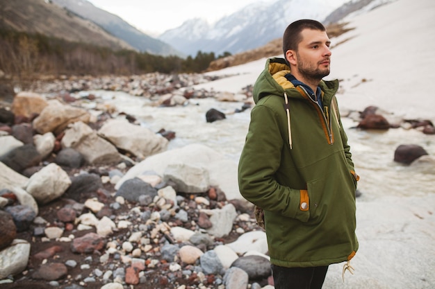 Uomo giovane hipster, escursioni in riva al fiume, natura selvaggia, vacanze invernali