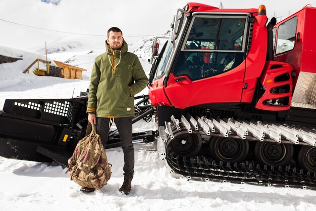 Young hipster man hiking in mountains, winter vacation traveling