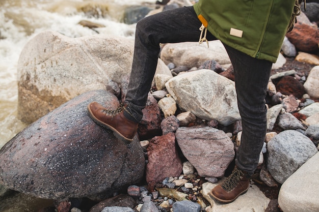 Young hipster man, hiking in wild nature, winter vacation, traveling, warm shoes, boots close up, details feet, legs