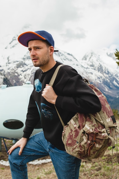 Free photo young hipster man sitting in mountains