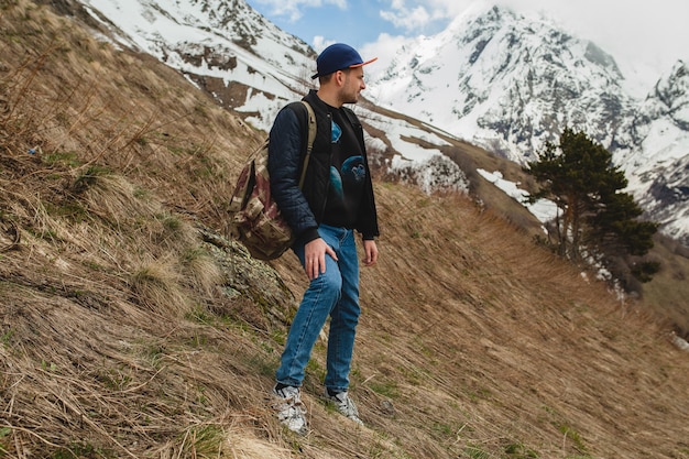 Free photo young hipster man sitting in mountains