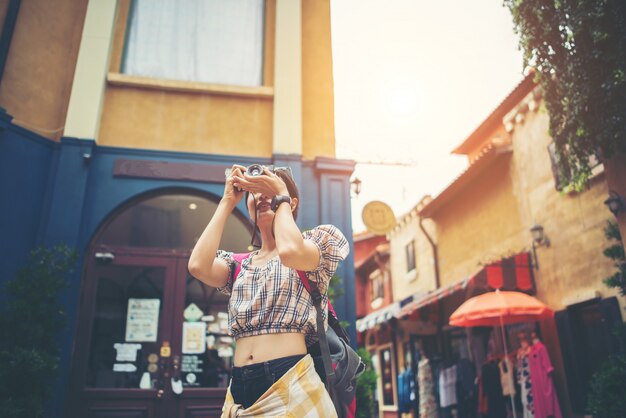 Молодая женщина хипстер наслаждаться фотографией в городе во время путешествия.
