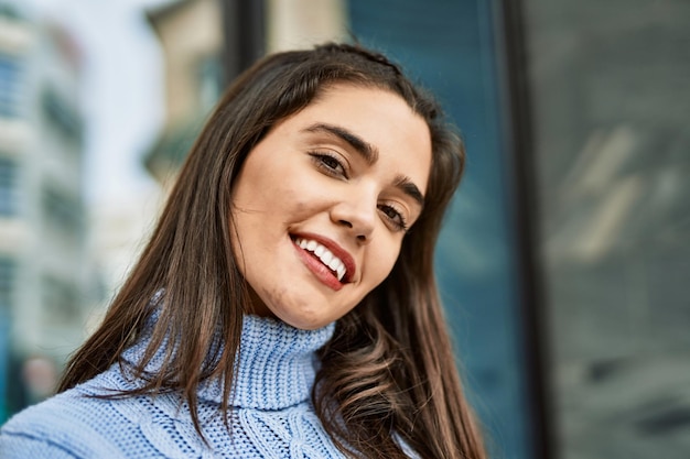 Free photo young hispanic girl smiling happy standing at the city