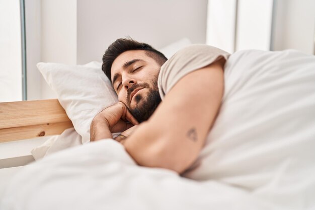 Young hispanic man sleeping on bed at bedroom