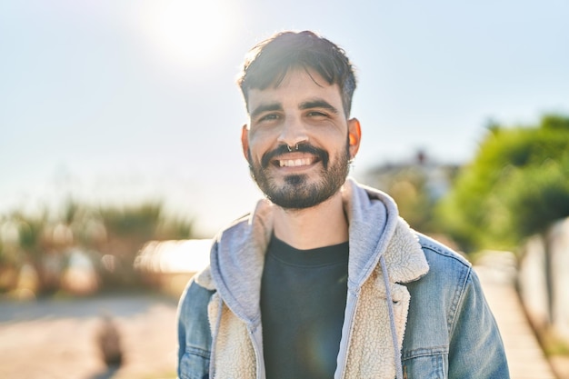 Young hispanic man smiling confident standing at street