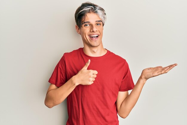 Young hispanic man wearing casual clothes showing palm hand and doing ok gesture with thumbs up smiling happy and cheerful