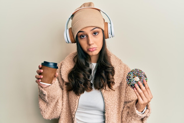 Free Photo young hispanic woman using headphones having breakfast depressed and worry for distress crying angry and afraid sad expression
